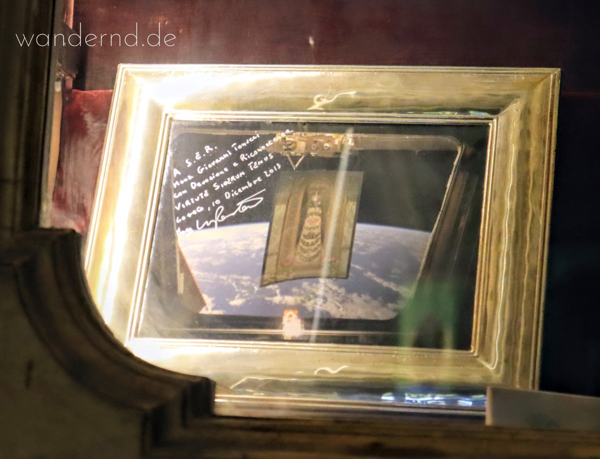 Die Madonna von Loreto als Schutzpatronin der Luft- und Raumfahrer. Dieses Bild befindet sich unter den Votivgaben des Gnadenorts. Der Spruch "Virtute siderum tenus" ist das Motto der italienischen Luftwaffe, deren Patronin ebenfalls die Madonna von Loreto ist.